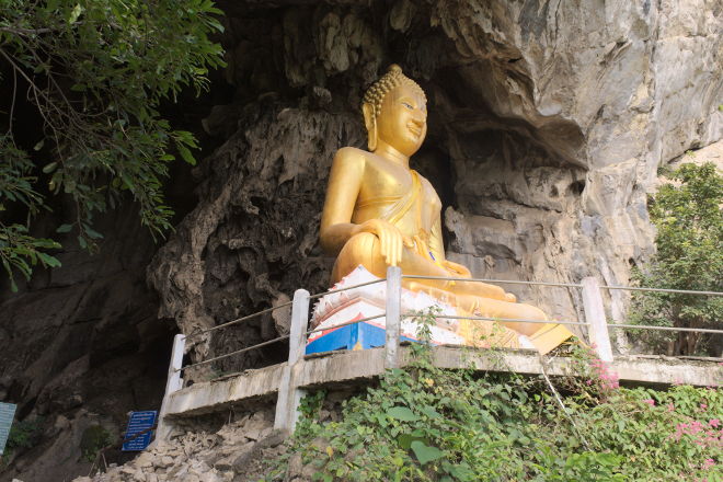 Buddha sidder ved indgangen til Erawan Cave